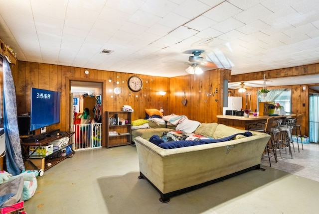 520 Munson St, Tow, TX 78672 - living area with visible vents, wood walls, finished concrete flooring, and ceiling fan