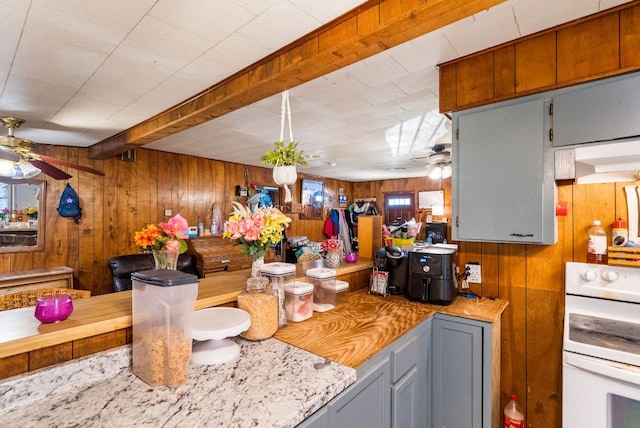 520 Munson St, Tow, TX 78672 - kitchen featuring wooden walls, ceiling fan, and stove