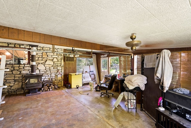 520 Munson St, Tow, TX 78672 - interior space featuring a wood stove, concrete flooring, and wood walls
