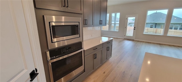 118 Freeman Day Dr, Bastrop, TX 78602 - kitchen with stainless steel appliances, light wood-style floors, light countertops, gray cabinets, and baseboards
