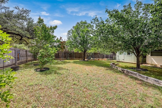 view of yard with an outdoor structure and a fenced backyard