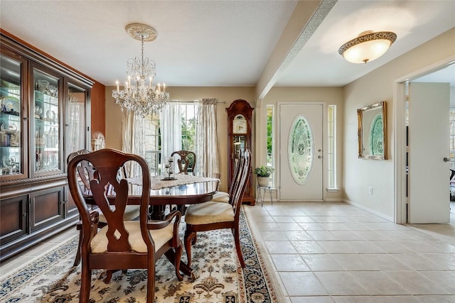 dining area with baseboards, a chandelier, and light tile patterned floors