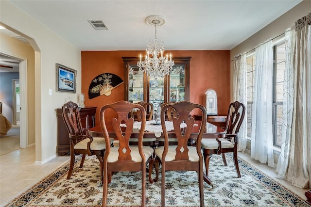 20603 Camel Back St, Lago Vista, TX 78645 - dining room featuring a chandelier, arched walkways, baseboards, and light tile patterned flooring