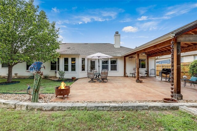 20603 Camel Back St, Lago Vista, TX 78645 - back of property featuring an outdoor fire pit, a chimney, a patio area, and a shingled roof