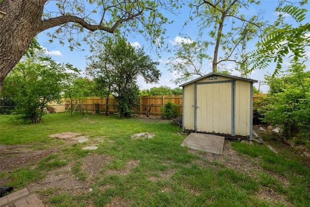 view of yard featuring an outbuilding, fence, and a storage shed