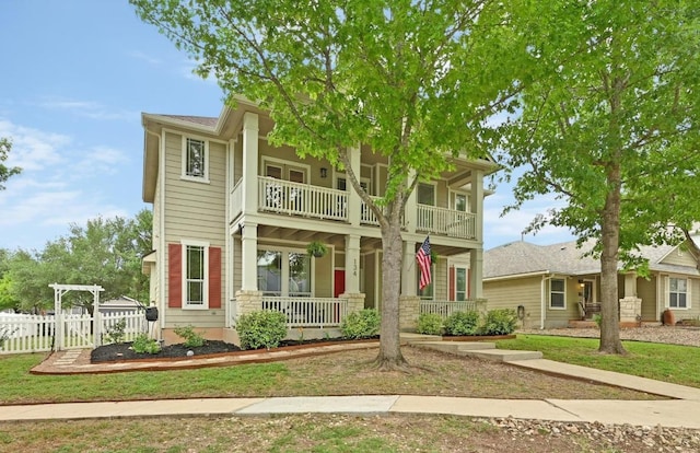 view of front of property featuring a porch, fence, and a balcony
