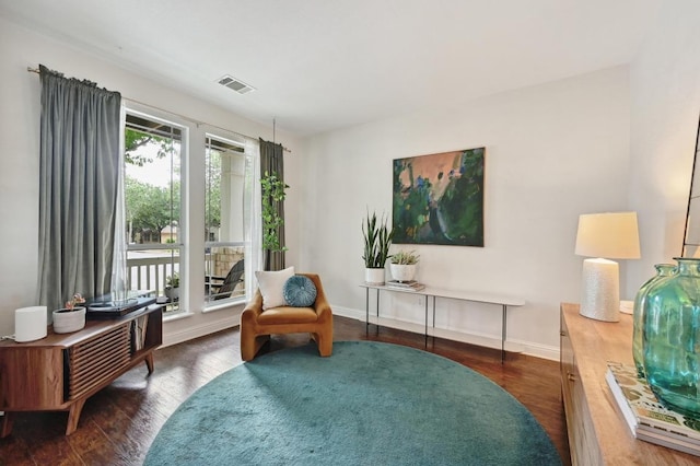 sitting room featuring baseboards, visible vents, and wood finished floors