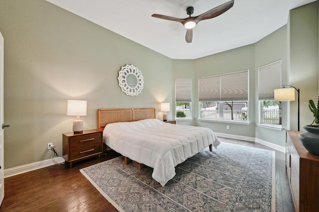 bedroom with baseboards, a ceiling fan, and dark wood-style floors
