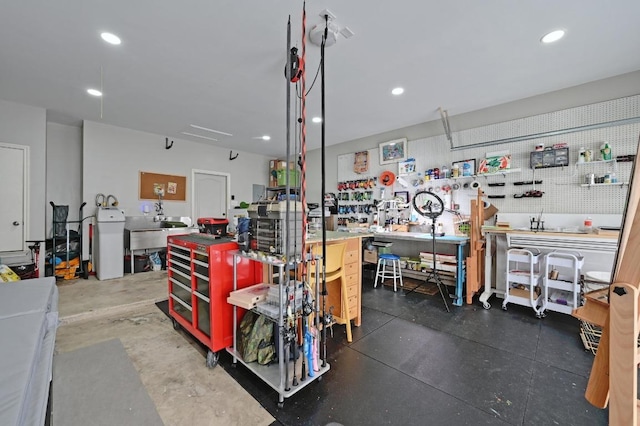 garage with recessed lighting, a workshop area, and a sink