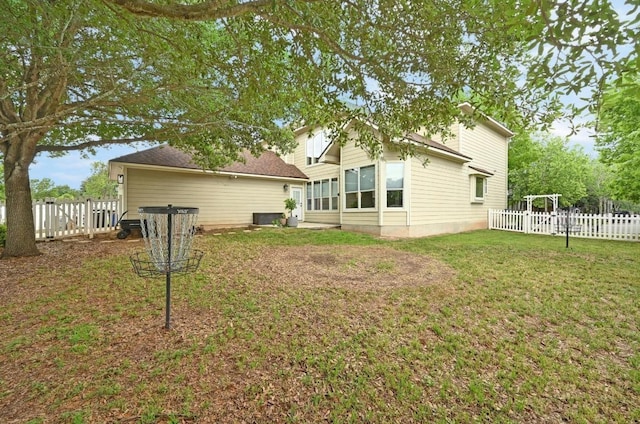 back of house with a fenced backyard, central AC unit, and a lawn