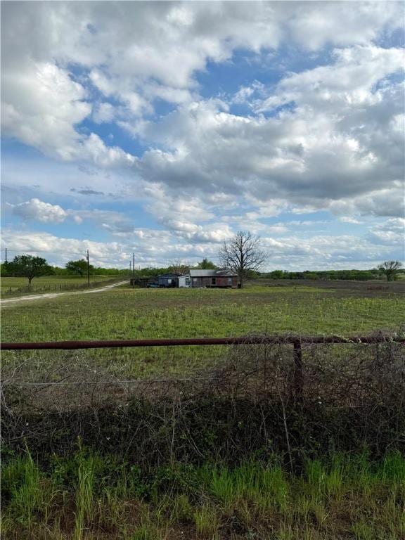 view of yard featuring fence and a rural view