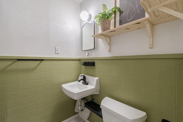 1052 Dunlap Dr, New Braunfels, TX 78130 - half bath featuring toilet, tile walls, wainscoting, and a sink