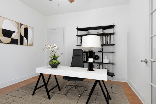 office featuring baseboards, ceiling fan, and wood finished floors