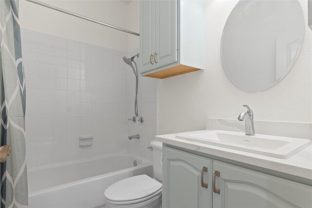 bathroom with vanity, shower / tub combo, and toilet