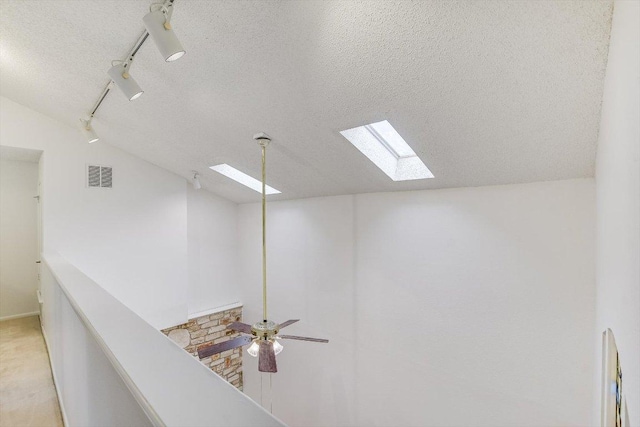 8518 Fathom Cir Unit 107, Austin, TX 78750 - detailed view of a skylight, a textured ceiling, a ceiling fan, and rail lighting