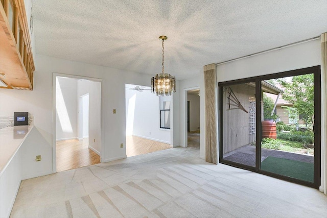 8518 Fathom Cir Unit 107, Austin, TX 78750 - unfurnished dining area featuring light colored carpet, a chandelier, a textured ceiling, ceiling fan, and baseboards