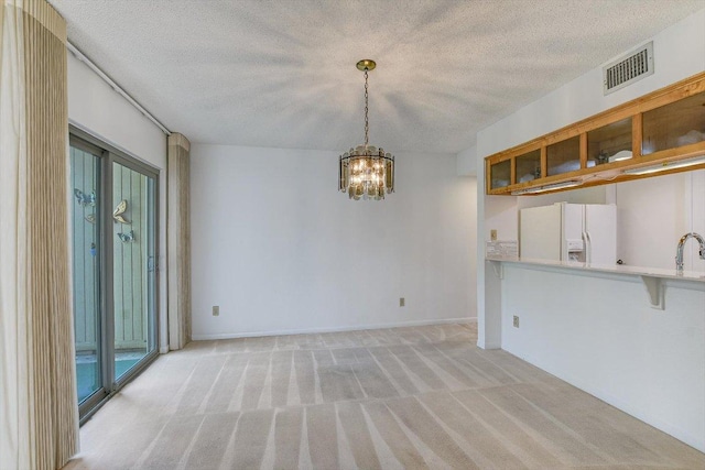 8518 Fathom Cir Unit 107, Austin, TX 78750 - unfurnished dining area featuring a textured ceiling, a chandelier, light carpet, baseboards, and a sink