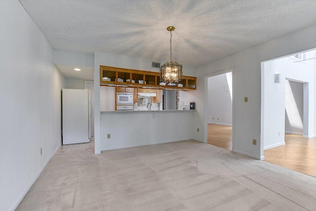 8518 Fathom Cir Unit 107, Austin, TX 78750 - unfurnished dining area with a chandelier, light carpet, baseboards, a textured ceiling, and recessed lighting