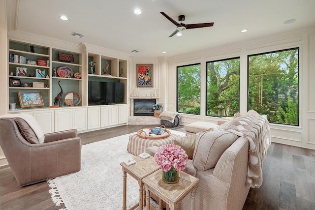3705 Dogwood Creek Cv, Austin, TX 78746 - living room featuring crown molding, a large fireplace, a ceiling fan, wood finished floors, and visible vents
