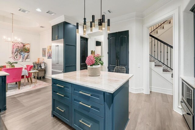 3705 Dogwood Creek Cv, Austin, TX 78746 - kitchen featuring blue cabinets, light wood finished floors, ornamental molding, built in refrigerator, and a chandelier