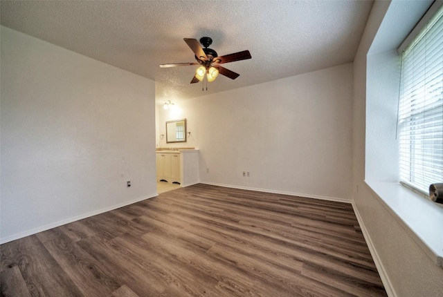 spare room featuring a healthy amount of sunlight, a textured ceiling, ceiling fan, and wood finished floors