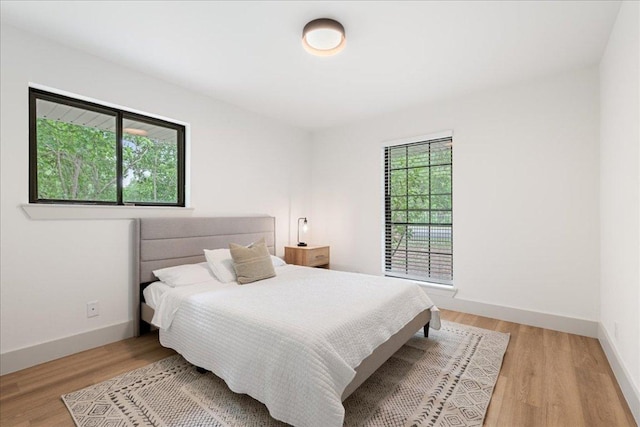 bedroom with baseboards and light wood-type flooring
