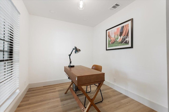 office featuring visible vents, light wood-style floors, and baseboards