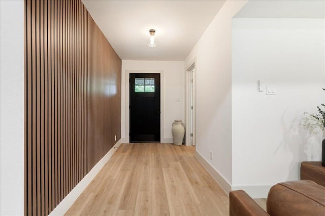 doorway with light wood-style floors and baseboards