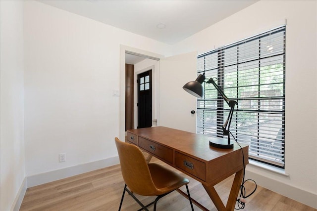 home office with baseboards and light wood-style floors