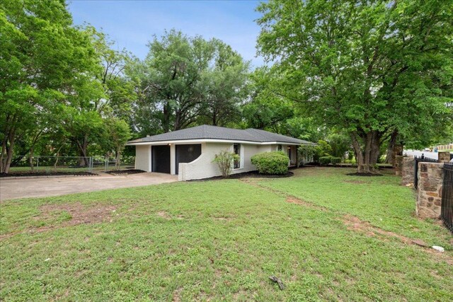 view of yard featuring fence and driveway