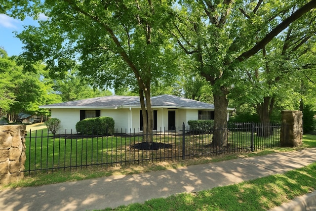 ranch-style house with a fenced front yard and a front yard
