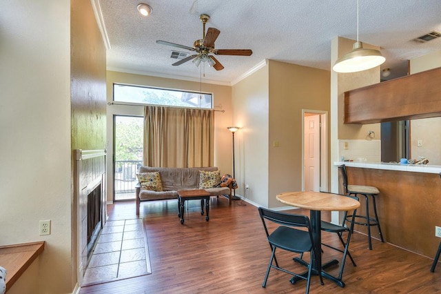 2802 Nueces St Unit 312, Austin, TX 78705 - living room with a textured ceiling, a ceiling fan, wood finished floors, a fireplace, and ornamental molding