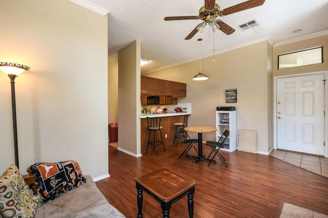 living room with visible vents, crown molding, ceiling fan, and wood finished floors