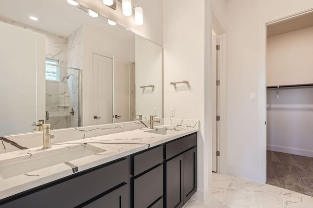 full bath featuring double vanity, a sink, a marble finish shower, and a walk in closet