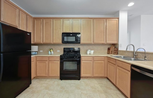 kitchen featuring light brown cabinetry, a sink, black appliances, and light countertops