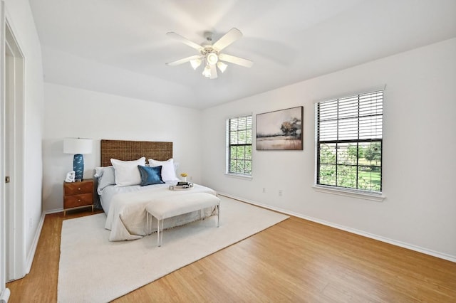 bedroom with a ceiling fan, baseboards, and wood finished floors