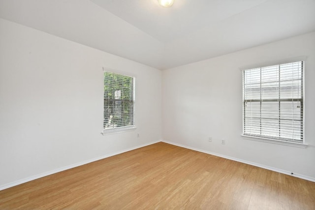 empty room with baseboards and light wood-type flooring