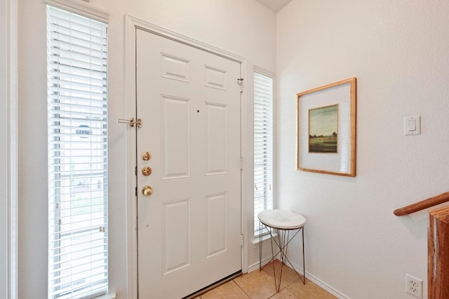 foyer entrance featuring baseboards and light tile patterned floors