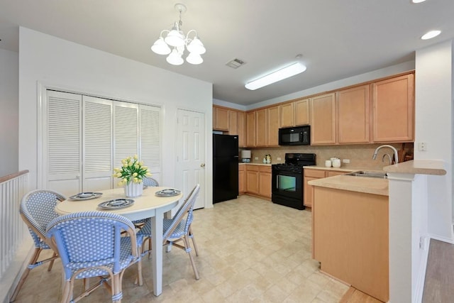 kitchen with an inviting chandelier, a sink, light countertops, visible vents, and black appliances