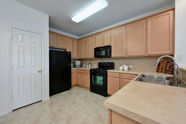 kitchen with light brown cabinetry, a sink, black appliances, and light countertops