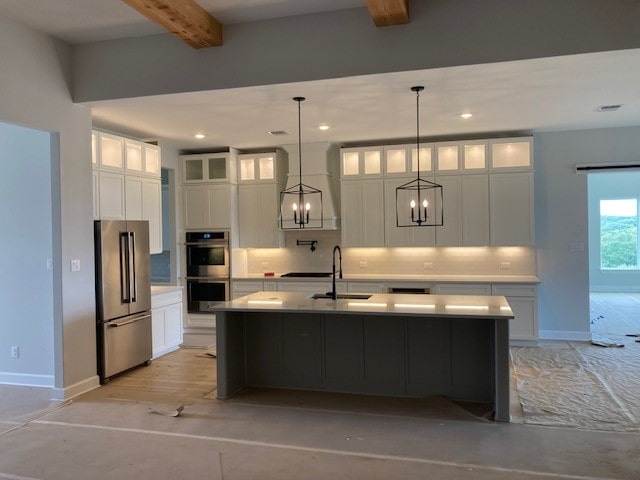 216 Cherry Sage Ct, Dripping Springs, TX 78620 - kitchen featuring appliances with stainless steel finishes, a sink, beamed ceiling, a notable chandelier, and white cabinetry