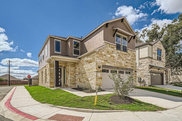 contemporary home featuring a garage, fence, concrete driveway, and stone siding