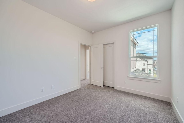 spare room with baseboards, carpet flooring, and a healthy amount of sunlight