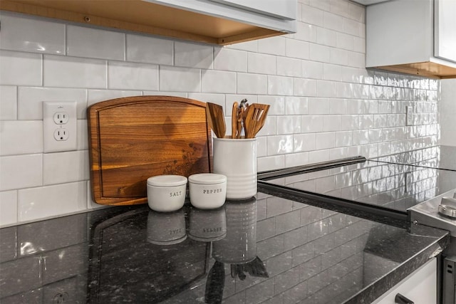 room details featuring dark stone counters and backsplash