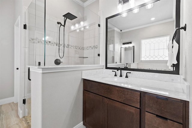 full bath with vanity, ornamental molding, baseboards, and a tile shower