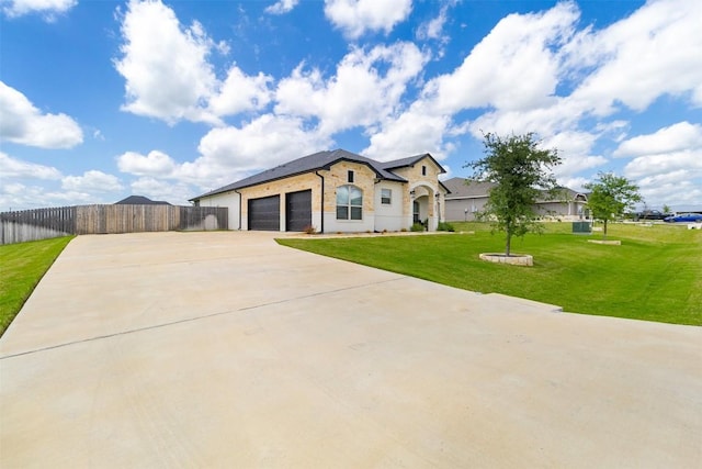 view of front of property featuring a front lawn, fence, brick siding, an attached garage, and driveway