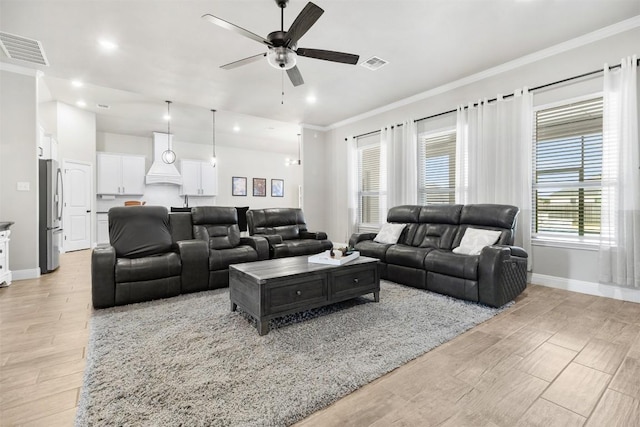 living room with a ceiling fan, baseboards, visible vents, and light wood-type flooring