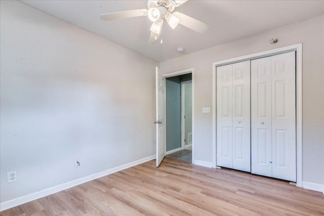 unfurnished bedroom featuring baseboards, ceiling fan, light wood-style flooring, and a closet