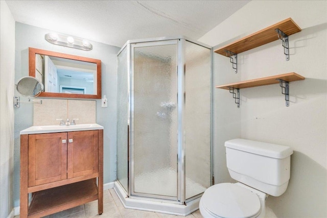 bathroom featuring vanity, tile patterned flooring, a stall shower, and toilet
