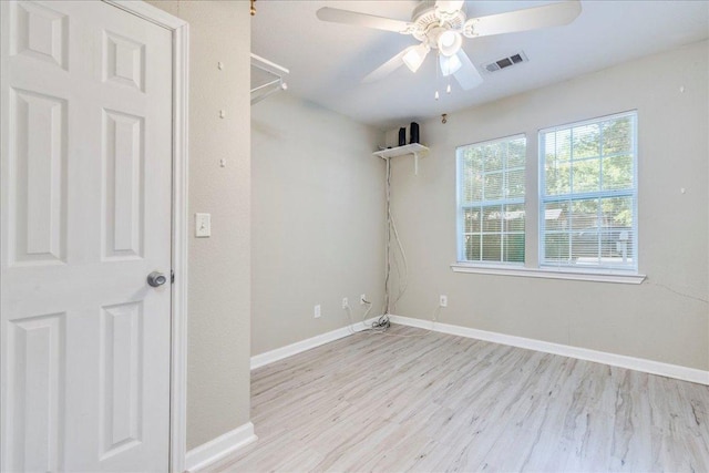 spare room featuring a ceiling fan, baseboards, visible vents, and wood finished floors